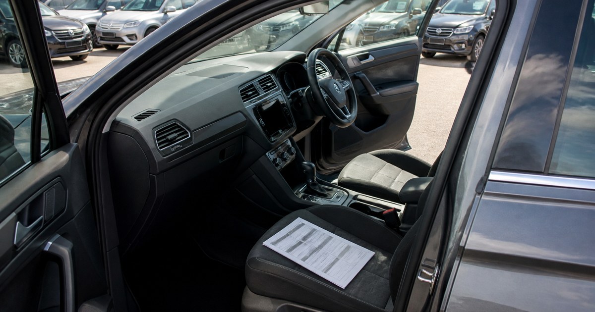 Vehicle history report on the passenger seat of a UK car